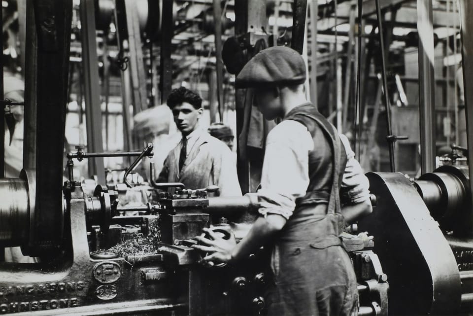 Two boys working in an factory. The photo is from D. Napier & Son Ltd, 'Aero Engine in the Making', from England, circa 1918